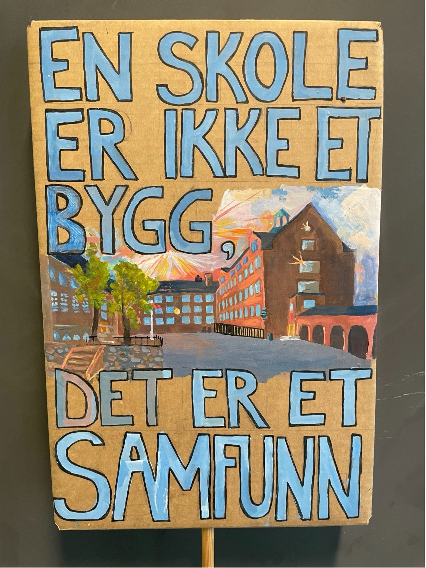 Et skilt med en bygning i bakgrunnen